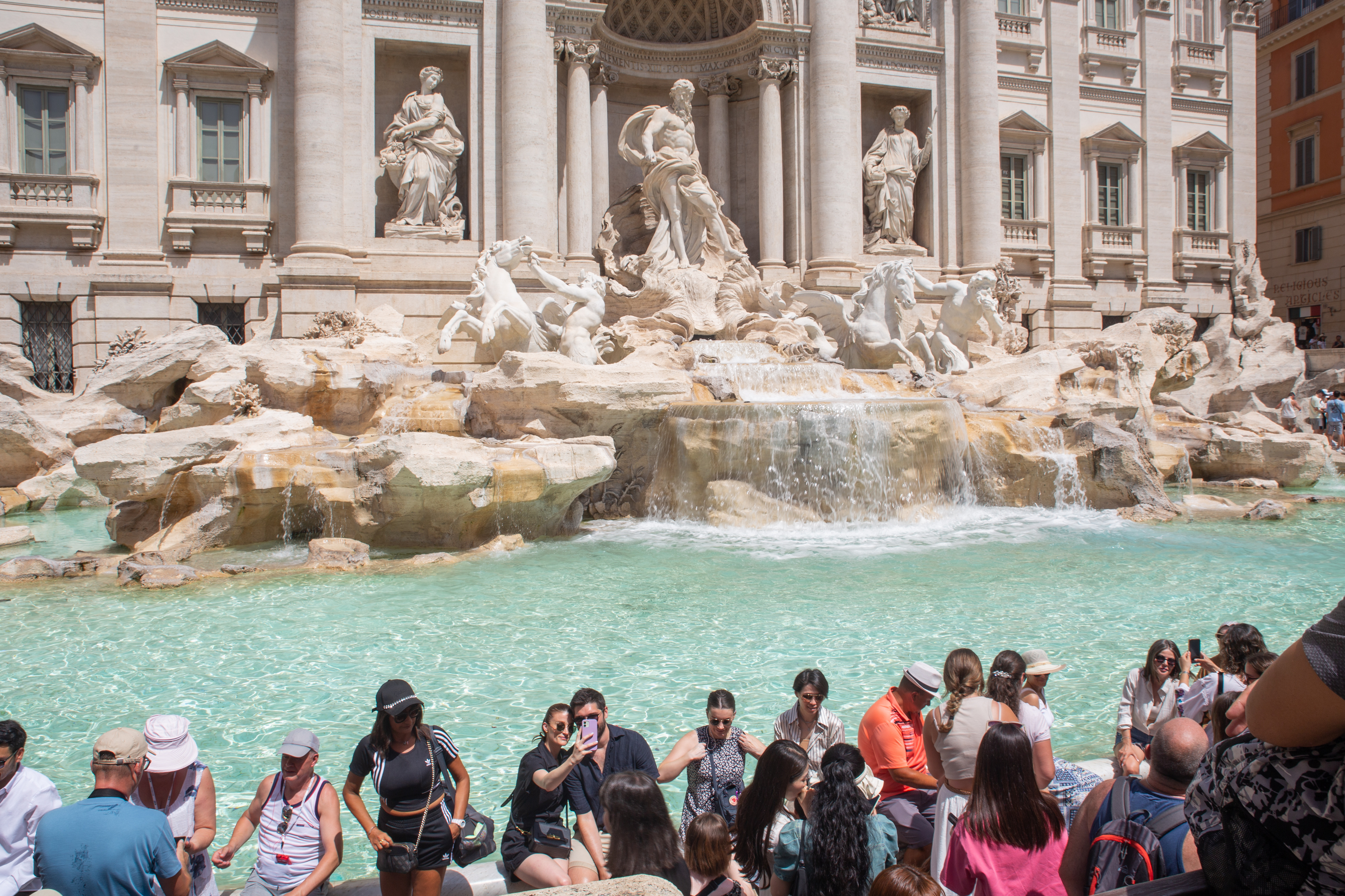 The Trevi Fountain with people in front of it 