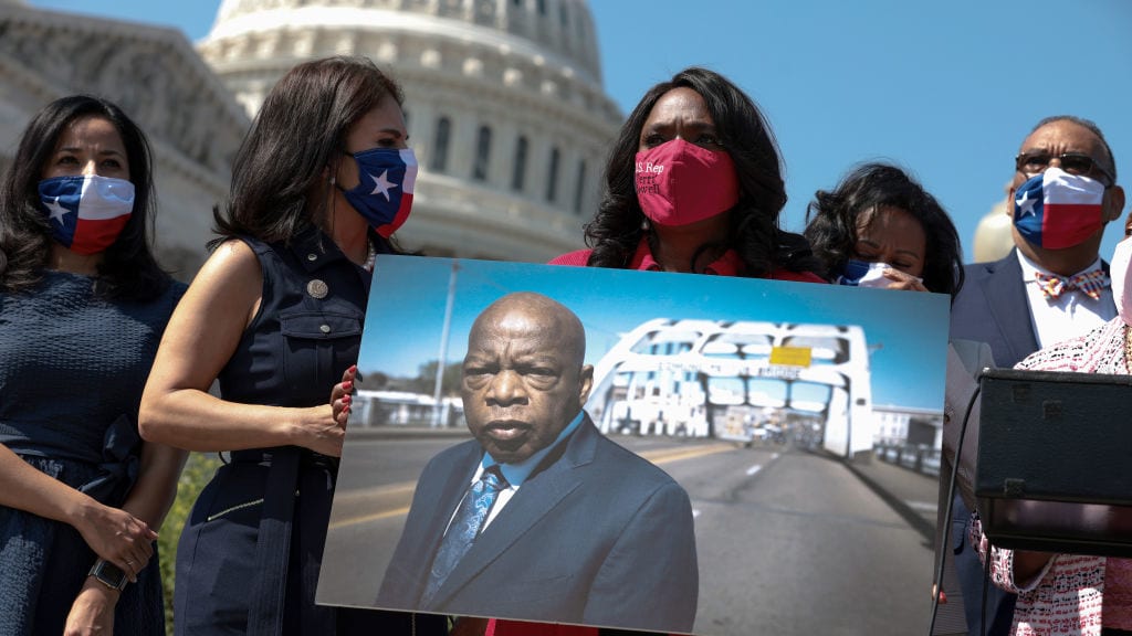 Rep. Terri Sewell holds a photo of the late Rep. John Lewis.