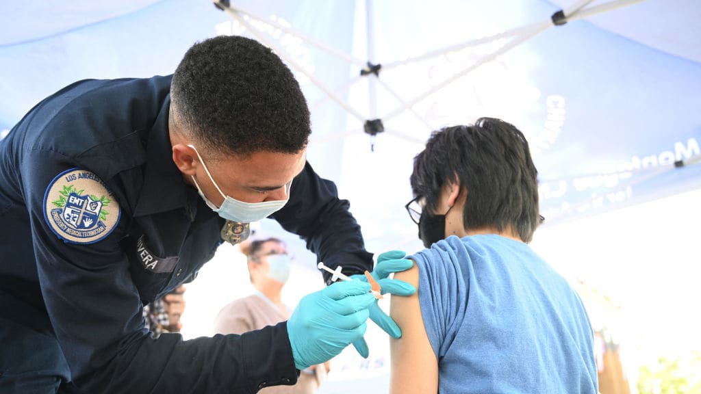 A teenager receives a COVID-19 vaccine.