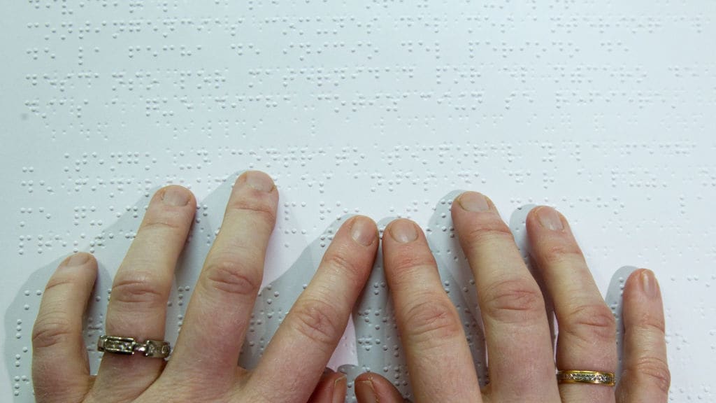 A person reads a book in Braille.