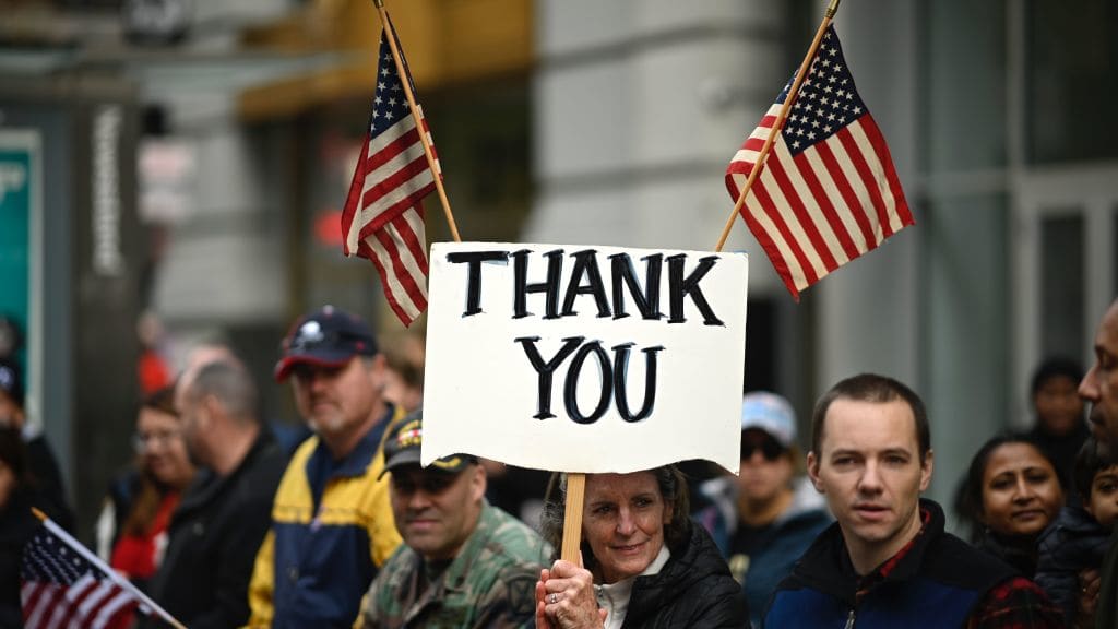 A woman holds a sign reading &quot;Thank You&quot; at a Veterans Day parade in New York City.