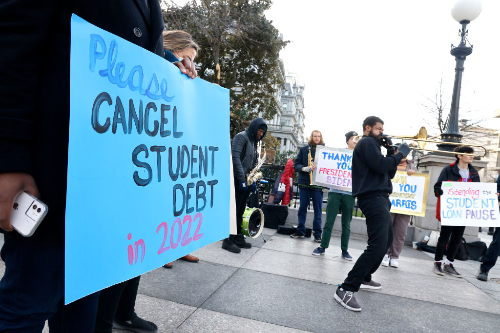 Protester holding student debt sign.