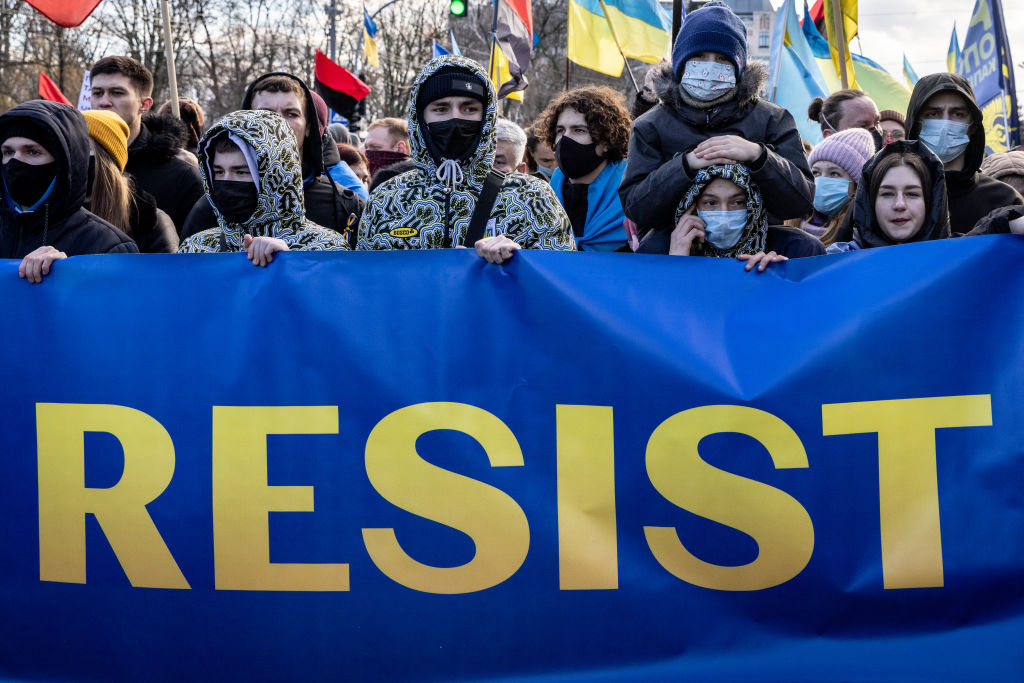 Ukrainian demonstrators carrying a sign that reads &quot;RESIST&quot;
