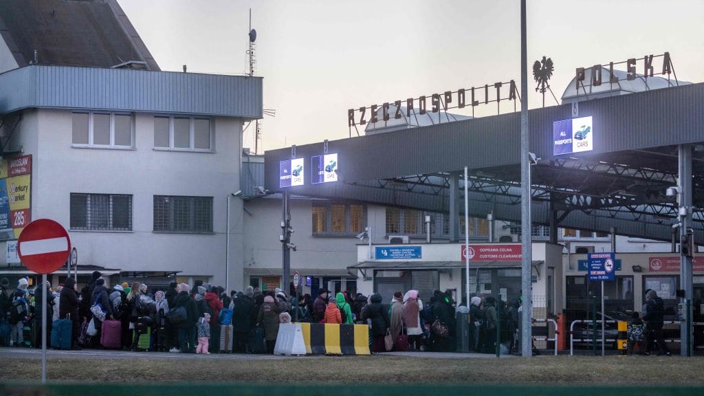 People fleeing Ukraine gather at the Polish border.