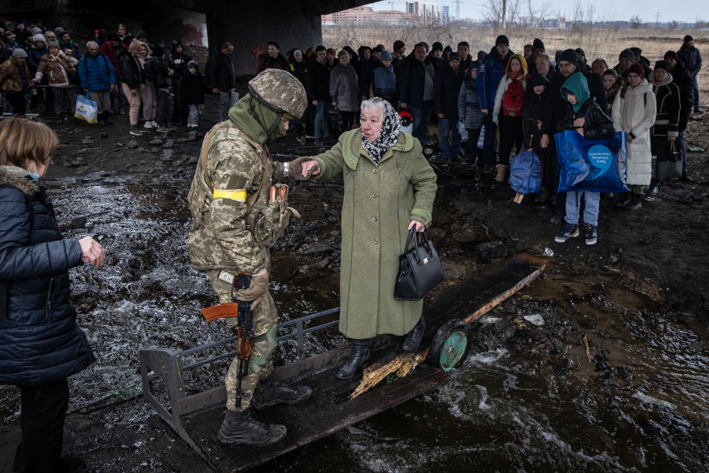 Ukrainian soldier helping an old woman
