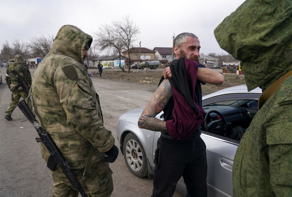 Russian-aligned separatist troops confront a Ukrainian civilian in Mariupol