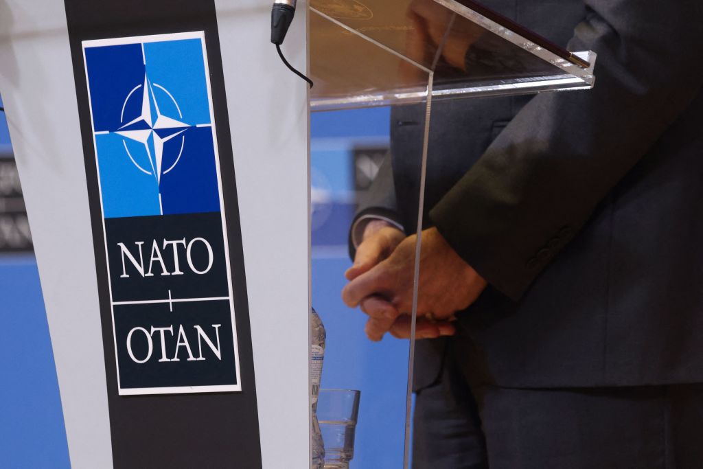 NATO logo on podium.