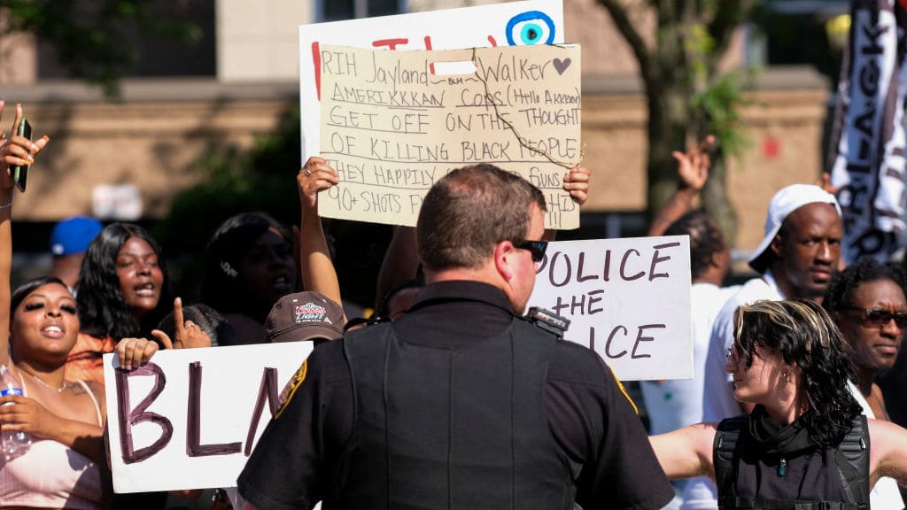 Demonstrators stand in front of a law enforcement officer in Akron, Ohio.