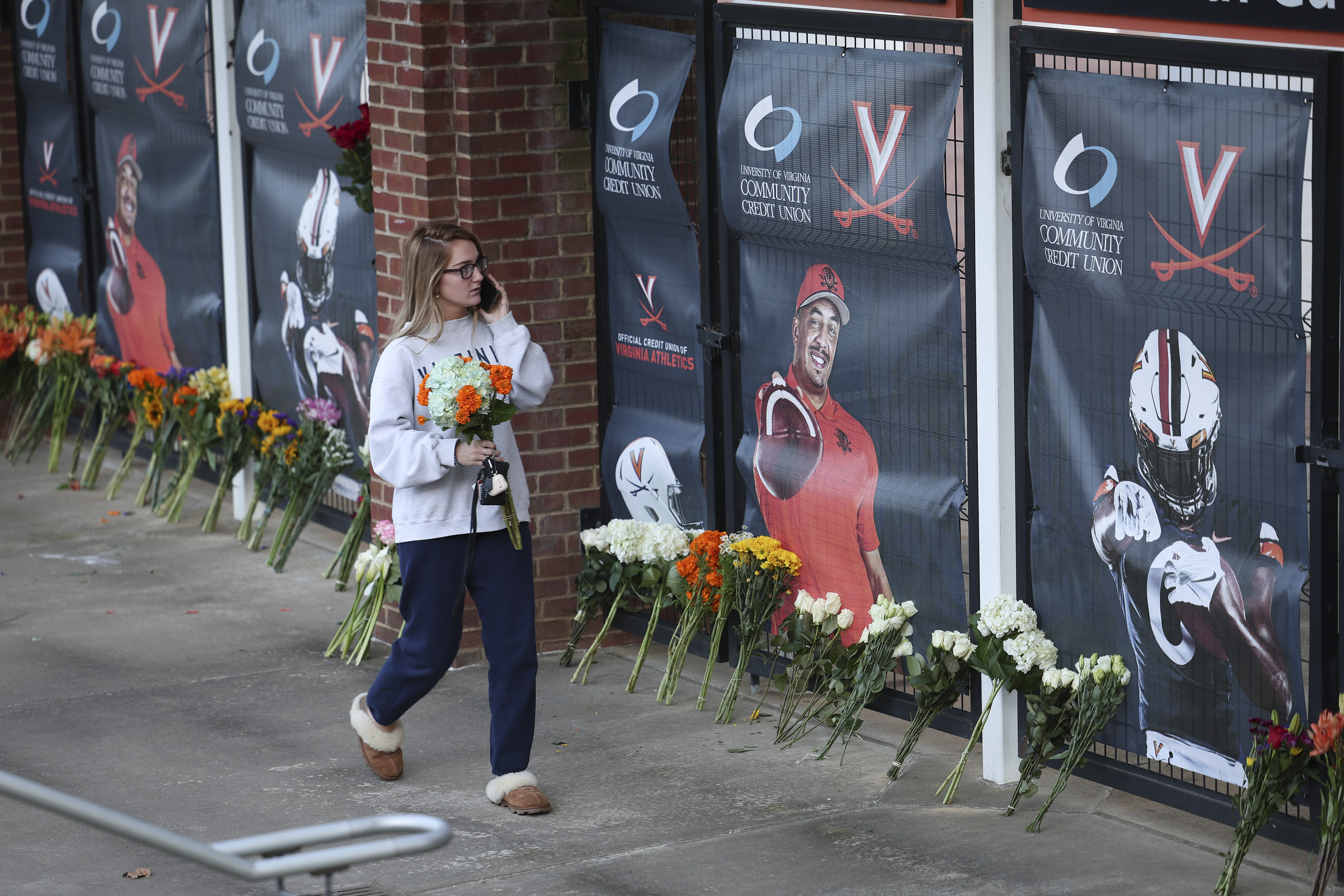 A student places flowers at a memorial following the shooting at UVA. 
