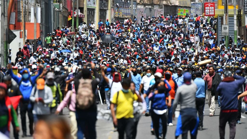 Supporters of former Peruvian President Pedro Castillo march in the street.