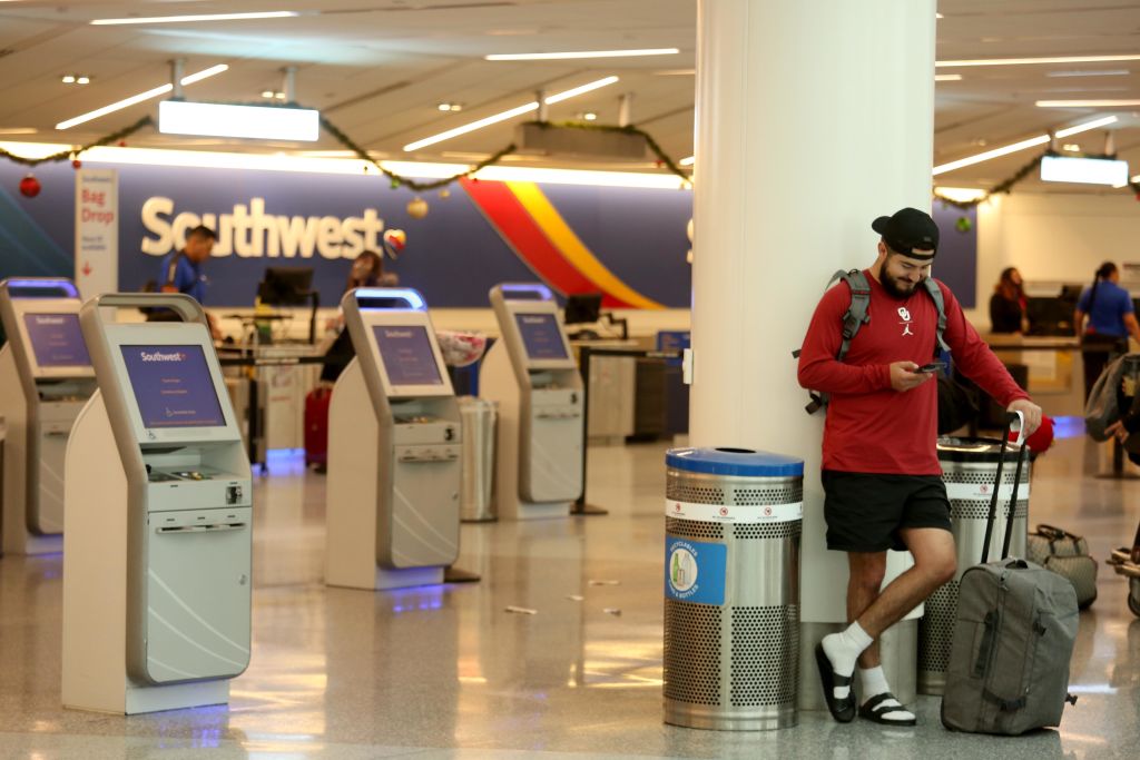 Passenger stands near Southwest Airlines ticketing counter.
