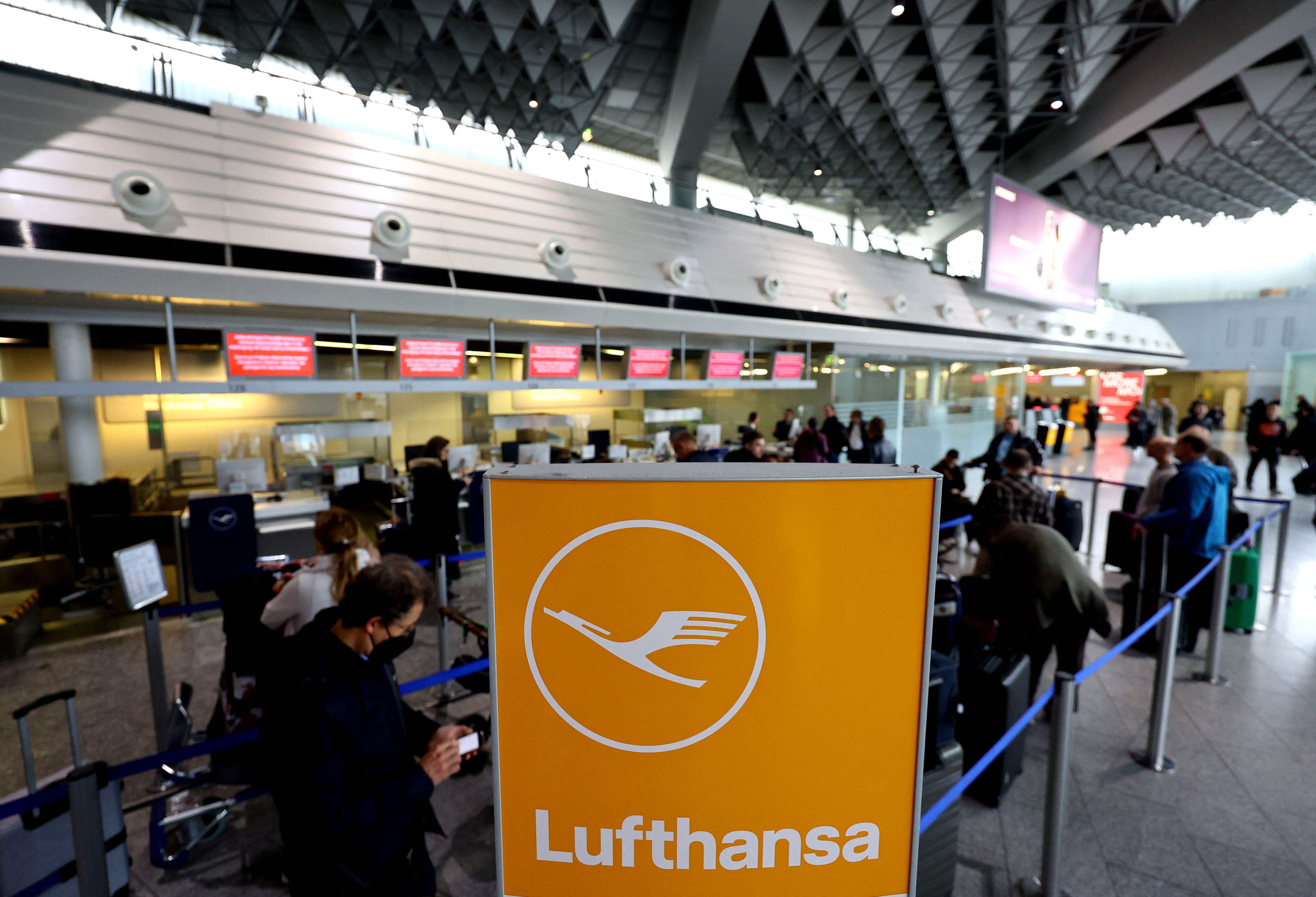 Passengers in line at a Lufthansa check-in following cancellations. 