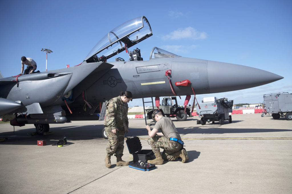U.S. aircraft technicians prepare an F-15 for takeoff. 