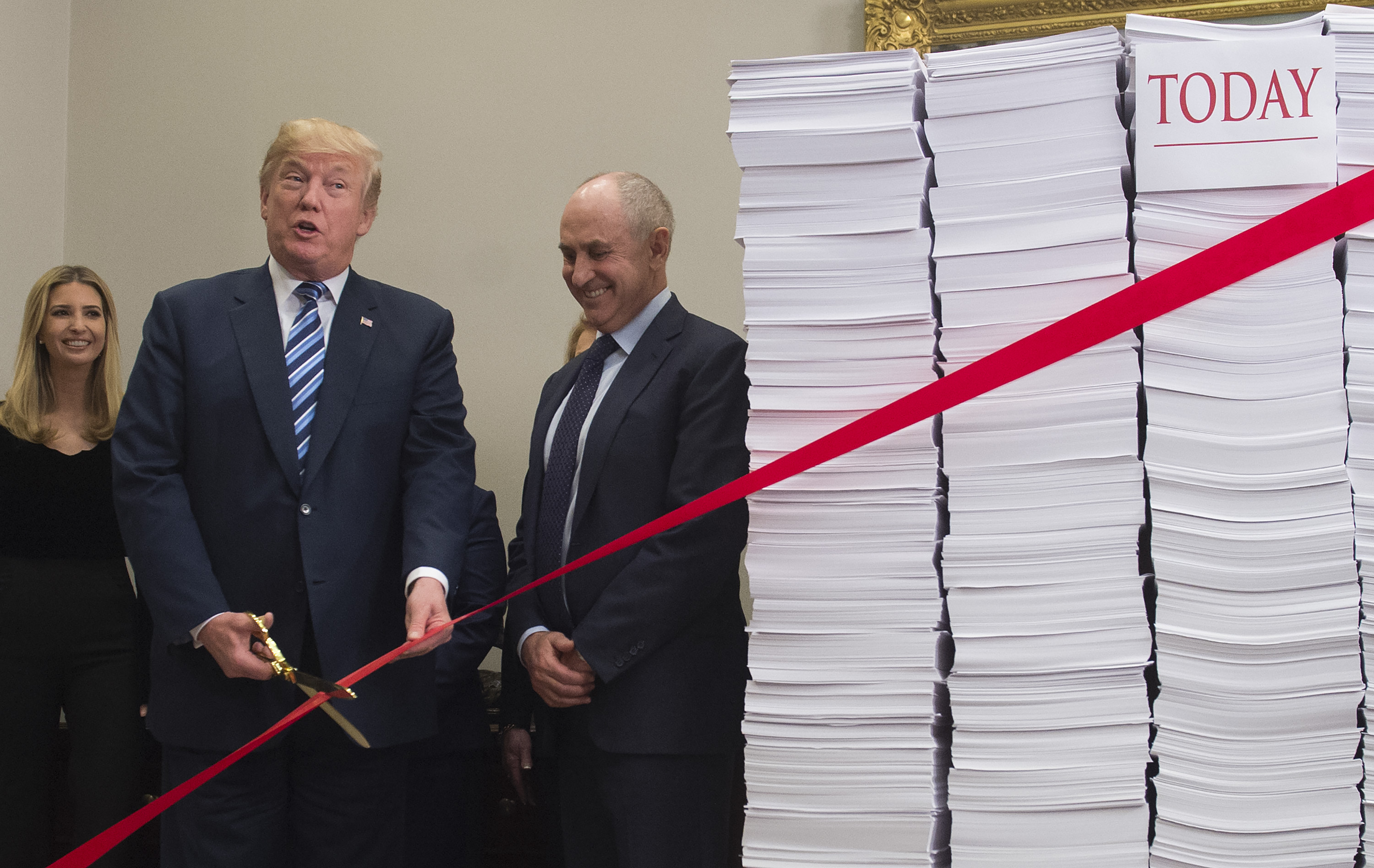 Donald Trump cutting red tape in front of tax documents