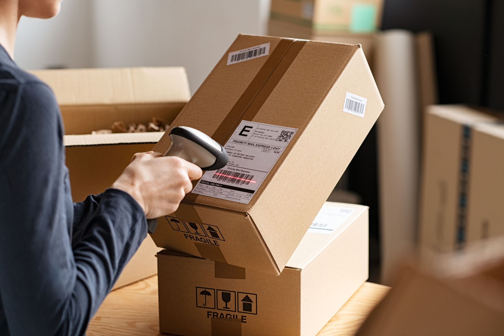 Woman scanning barcode on delivery parcel.